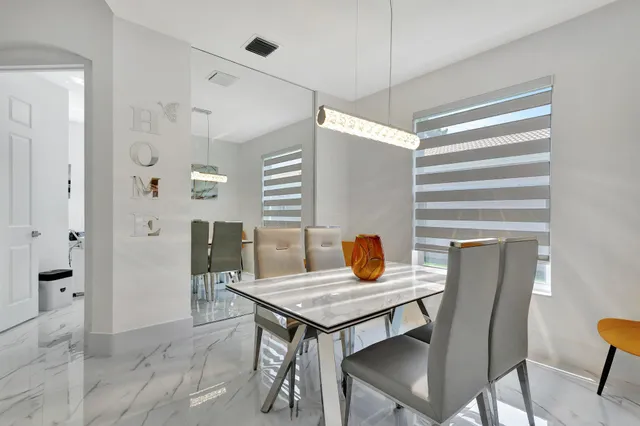 a kitchen with stainless steel appliances kitchen island granite countertop a sink and a refrigerator