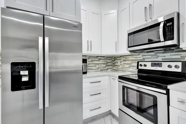 a kitchen with stainless steel appliances a stove microwave and sink