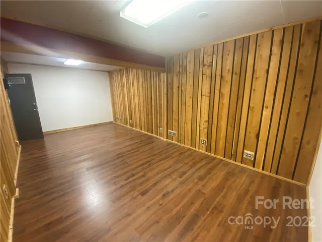 a view of a room with wooden floor