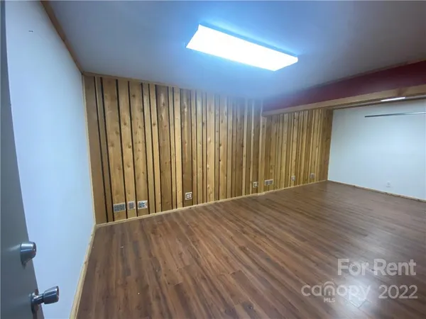 a view of a room with wooden floor and a window