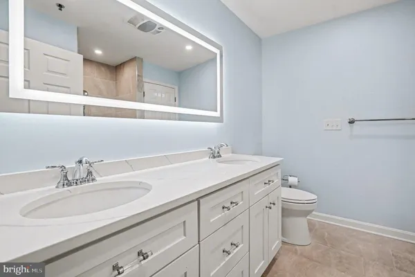 a bathroom with a granite countertop sink and a toilet