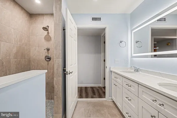 a bathroom with a granite countertop sink a toilet and shower
