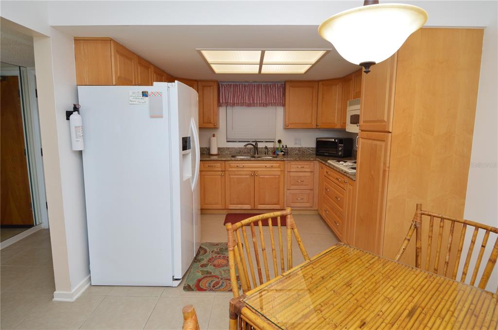 900 Gulf Boulevard, Unit 907 Indian Rocks Beach, FL 33785 - Photo 6 of 88 a kitchen with a refrigerator a stove a sink dishwasher and wooden cabinets with wooden floor