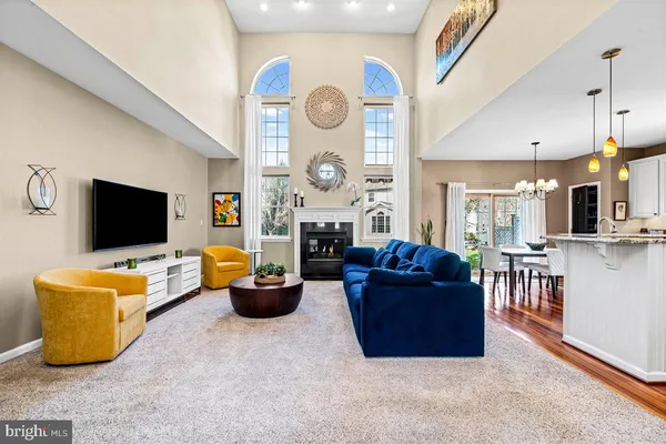 a view of a dining room and livingroom with furniture wooden floor a chandelier