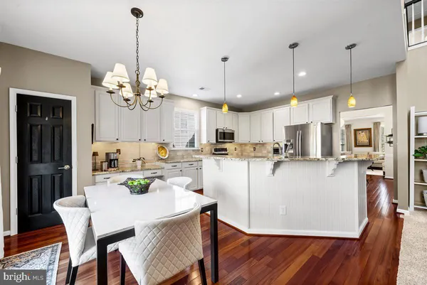 a kitchen with stainless steel appliances granite countertop a sink stove and wooden floor