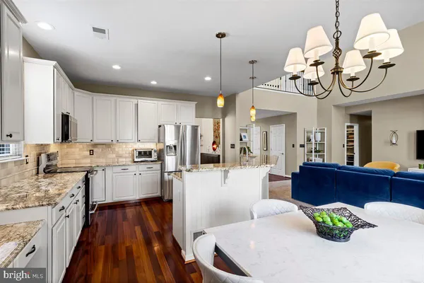 a kitchen with stainless steel appliances granite countertop sink stove and refrigerator