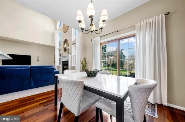 a view of a dining room with furniture a chandelier and wooden floor