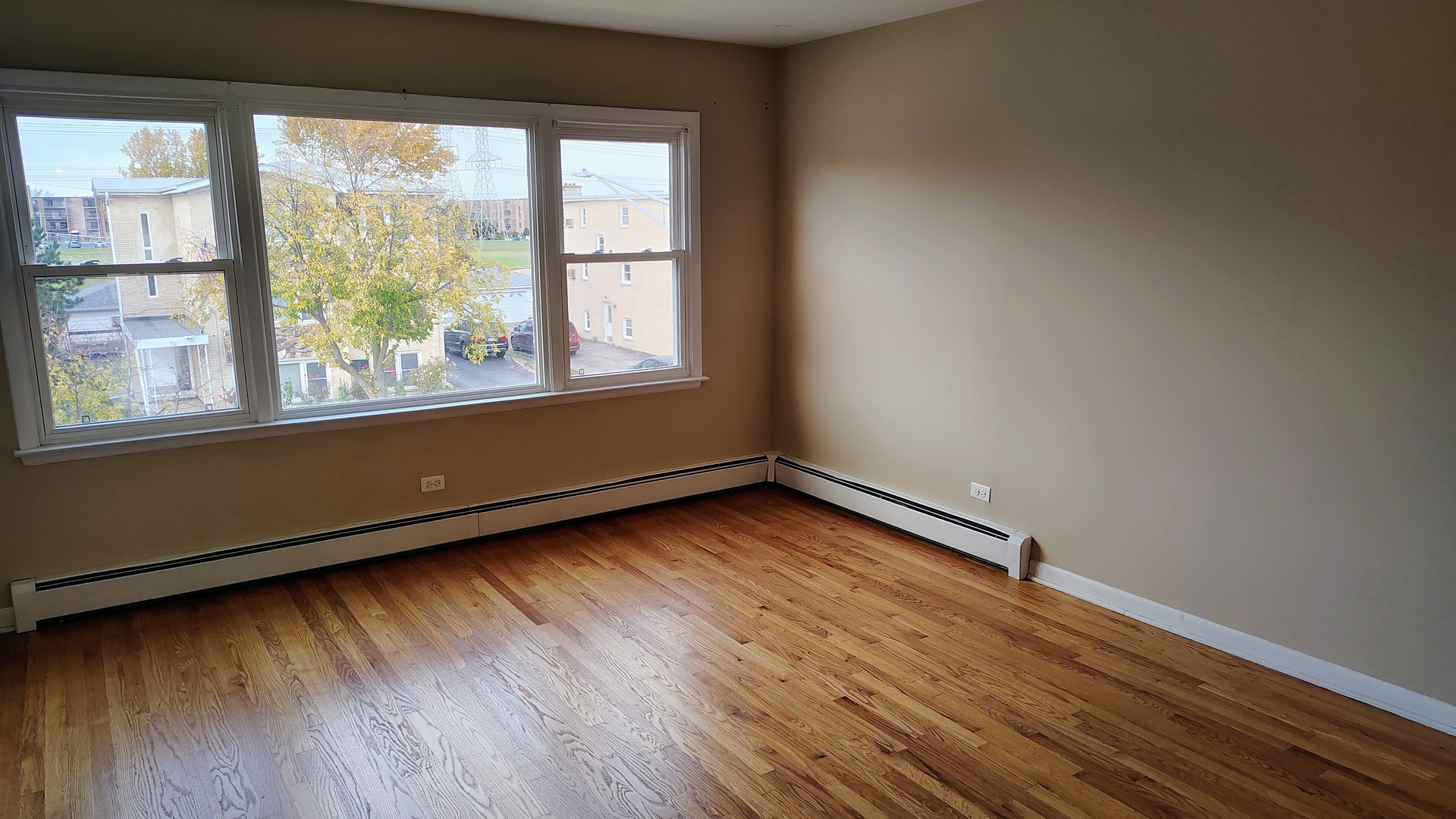 539 Ida Court, Unit 2 Mount Prospect, IL 60056 - Photo 2 of 9 an empty room with wooden floor and windows