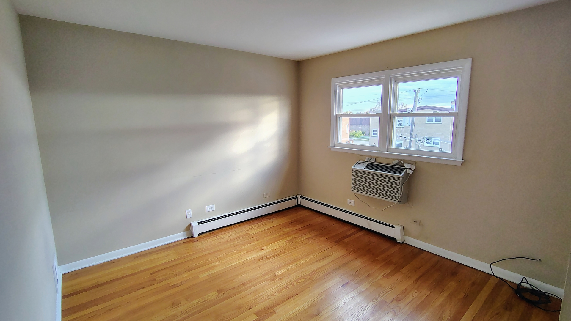 539 Ida Court, Unit 2 Mount Prospect, IL 60056 - Photo 5 of 9 an empty room with wooden floor and windows