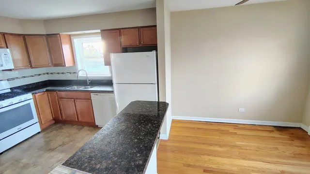 a kitchen with a refrigerator and a stove top oven