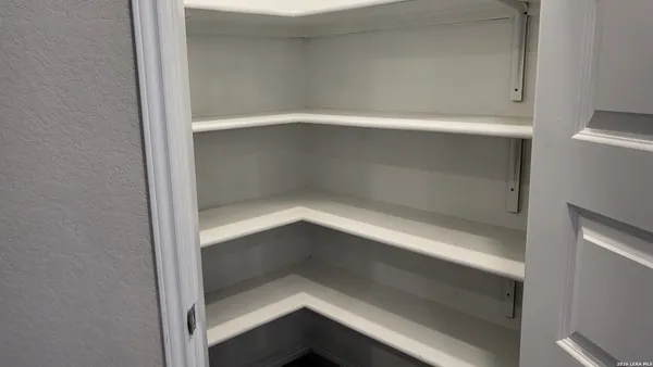 a view of an empty room with closet and wooden door