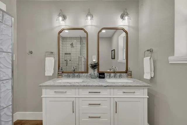 a bathroom with double vanity sinks and a mirror