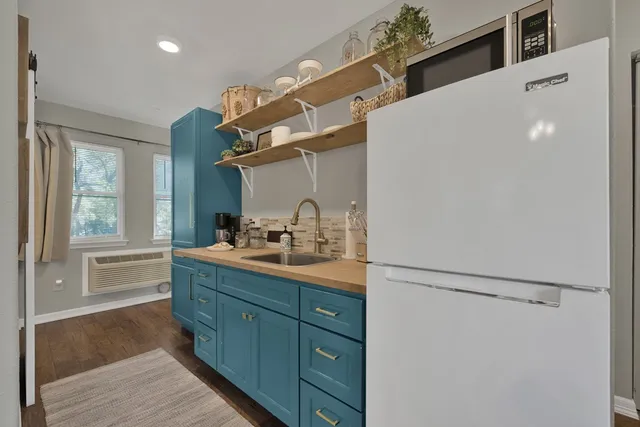 a kitchen with stainless steel appliances granite countertop a sink and a refrigerator