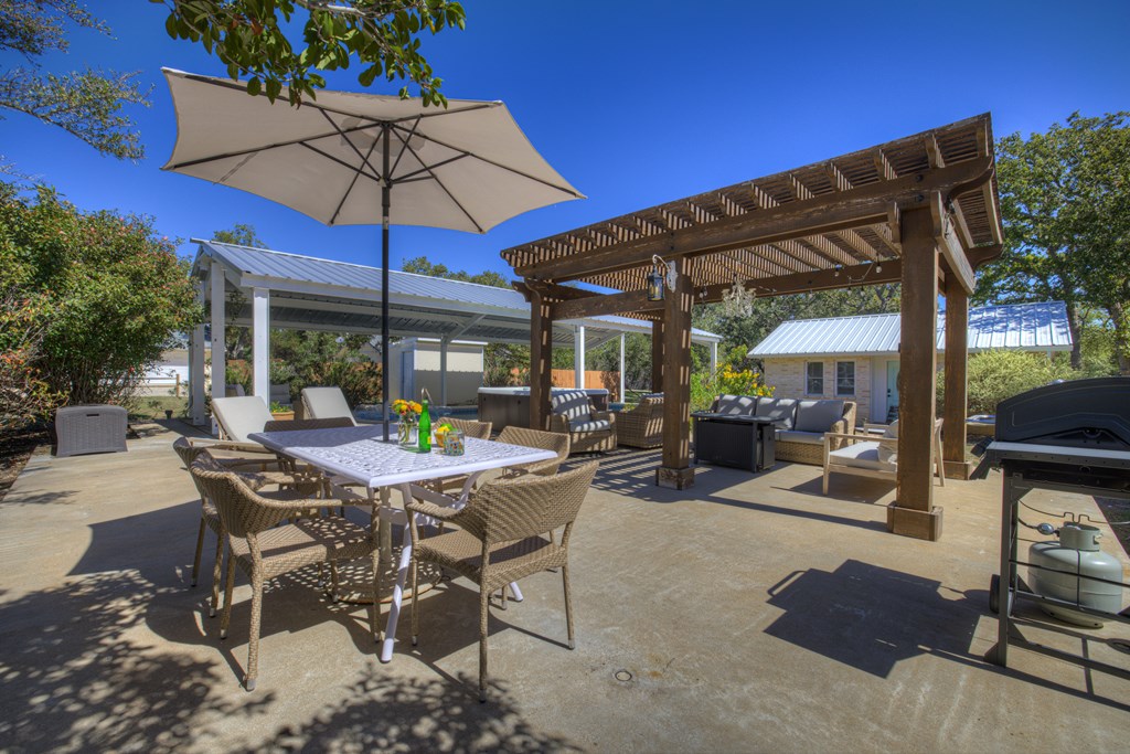 113 Weitz Road Fredericksburg, TX 78624 - Photo 27 of 50 a view of a patio with table and chairs under an umbrella