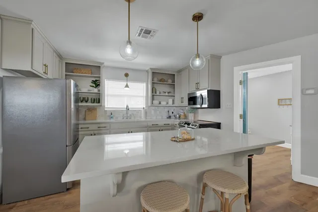 a kitchen with a table chairs refrigerator and microwave