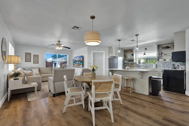 a dining room with kitchen island stainless steel appliances furniture a dining table and chairs