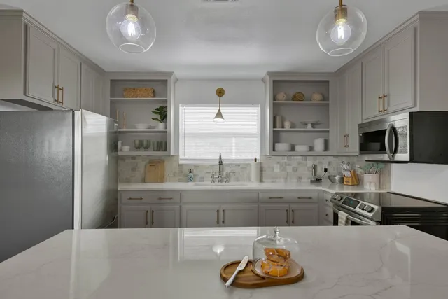 a kitchen with stainless steel appliances granite countertop a sink and cabinets