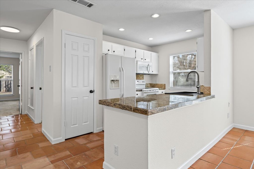 303 Fantail Loop, Unit A Austin, TX 78734 - Photo 11 of 28 a kitchen with stainless steel appliances granite countertop a sink and cabinets