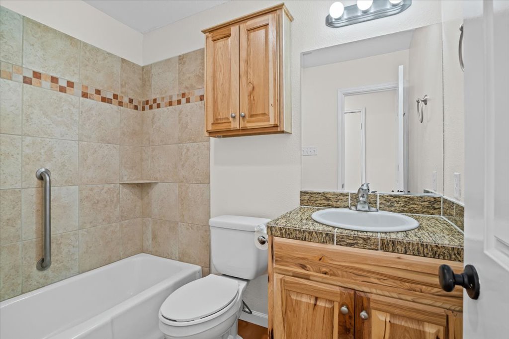303 Fantail Loop, Unit A Austin, TX 78734 - Photo 18 of 28 a bathroom with a granite countertop sink mirror vanity and toilet