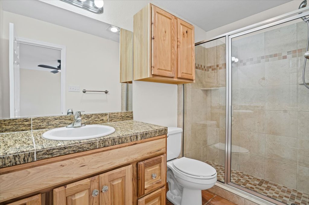 303 Fantail Loop, Unit A Austin, TX 78734 - Photo 21 of 28 a bathroom with a granite countertop sink toilet and shower