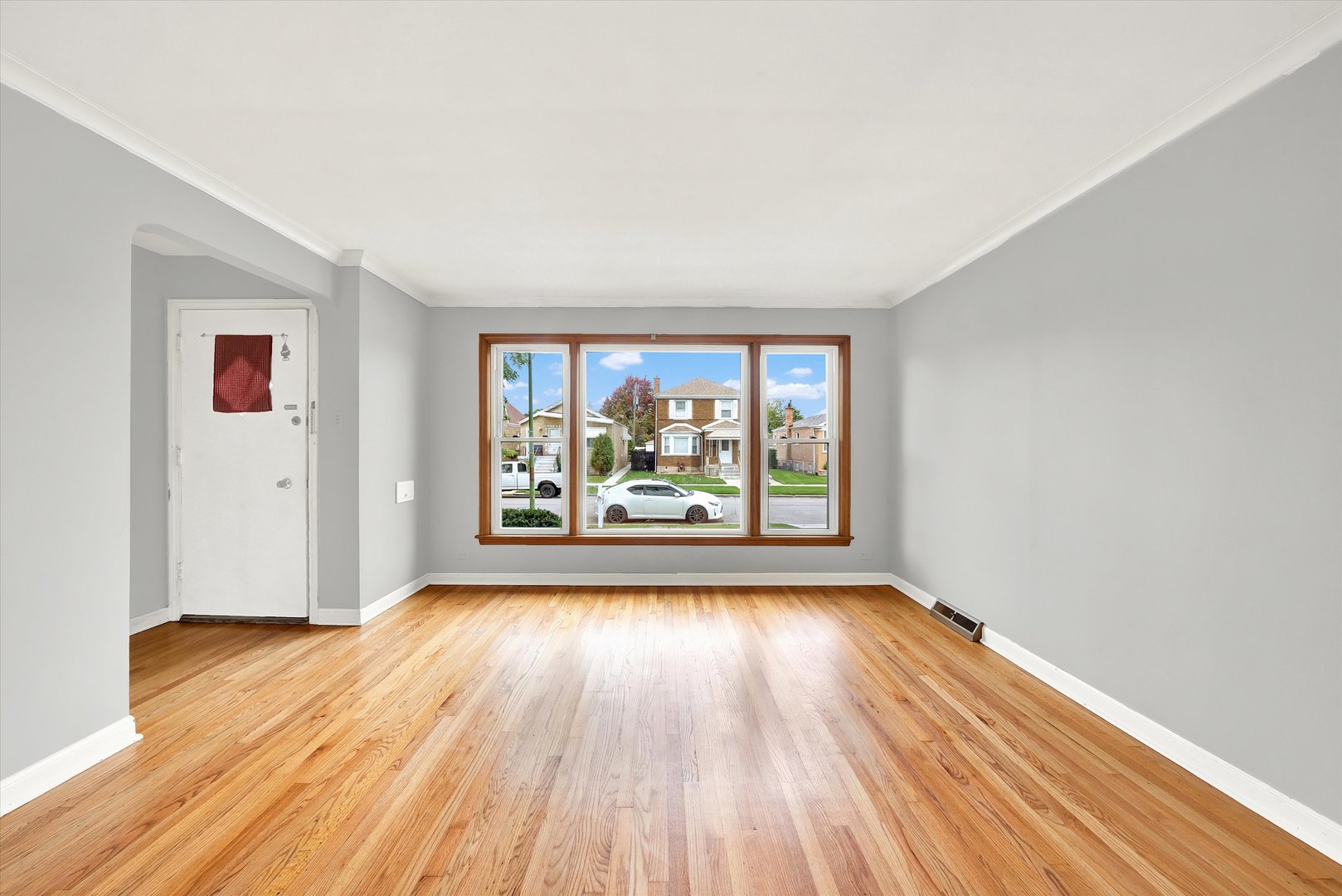 3933 West 58th Street Chicago, IL 60629 - Photo 2 of 32 an empty room with wooden floor and windows