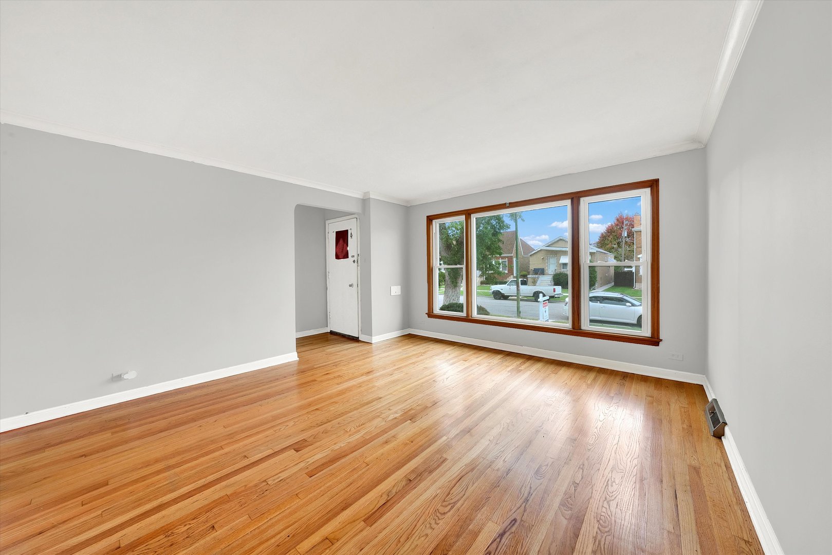 3933 West 58th Street Chicago, IL 60629 - Photo 3 of 32 an empty room with wooden floor and windows