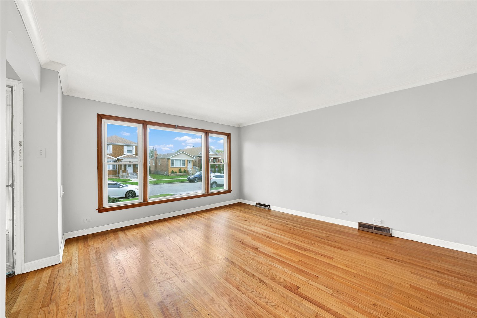 3933 West 58th Street Chicago, IL 60629 - Photo 4 of 32 an empty room with wooden floor and windows