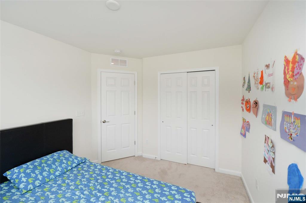 12-48 Plaza Road Fair Lawn, NJ 07410 - Photo 11 of 26 a bedroom with a dresser and a picture of white wall