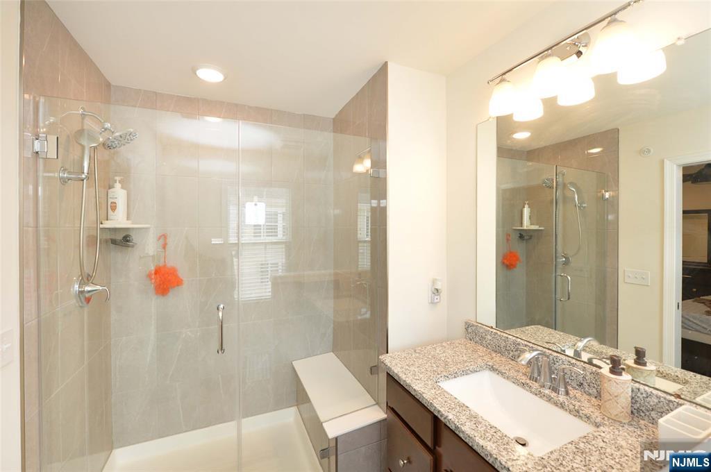12-48 Plaza Road Fair Lawn, NJ 07410 - Photo 18 of 26 a bathroom with a granite countertop sink shower and a mirror