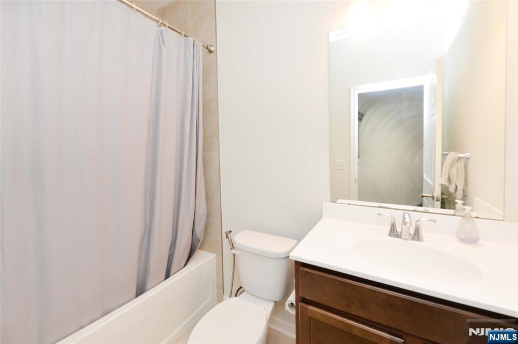 12-48 Plaza Road Fair Lawn, NJ 07410 - Photo 22 of 26 a bathroom with a sink a toilet a mirror and shower