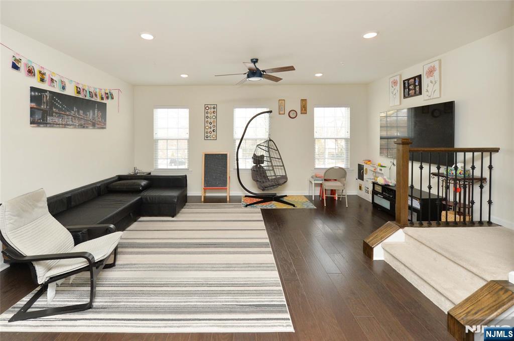 12-48 Plaza Road Fair Lawn, NJ 07410 - Photo 3 of 26 a living room with couches a coffee table a flat screen tv and a large window with garden view