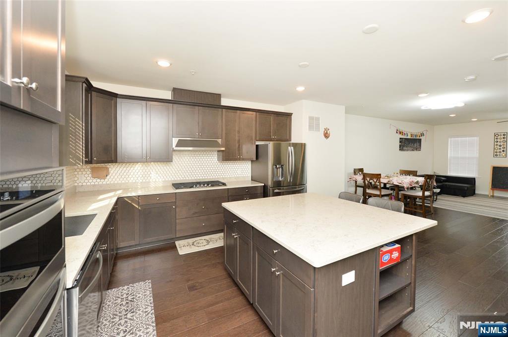12-48 Plaza Road Fair Lawn, NJ 07410 - Photo 7 of 26 a kitchen with kitchen island wooden cabinets a sink and a stove