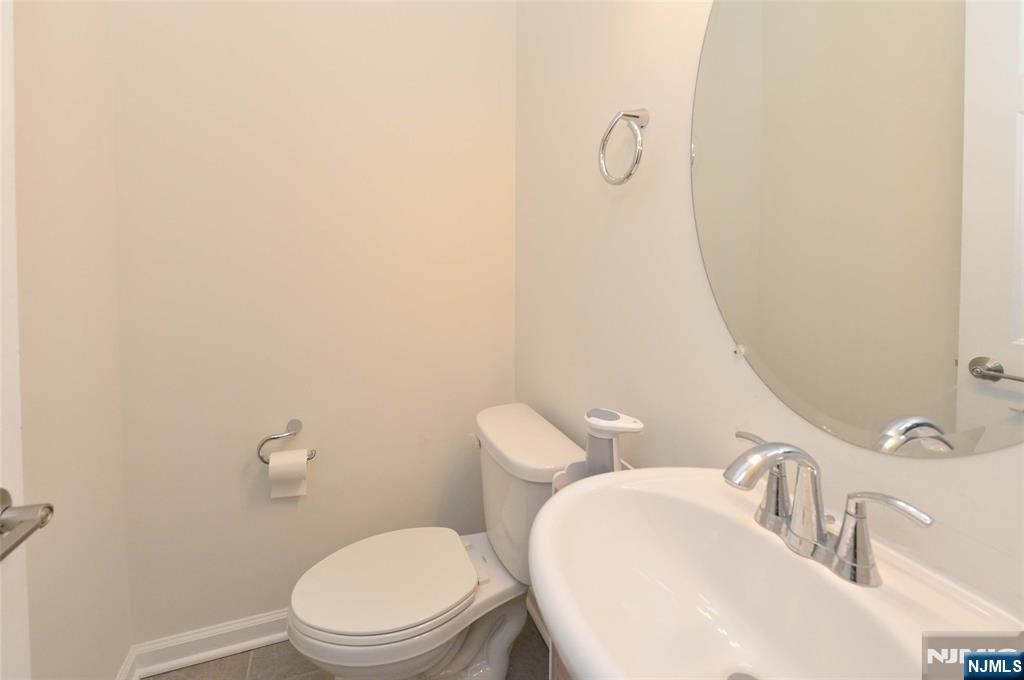 12-48 Plaza Road Fair Lawn, NJ 07410 - Photo 9 of 26 a bathroom with a toilet sink and mirror