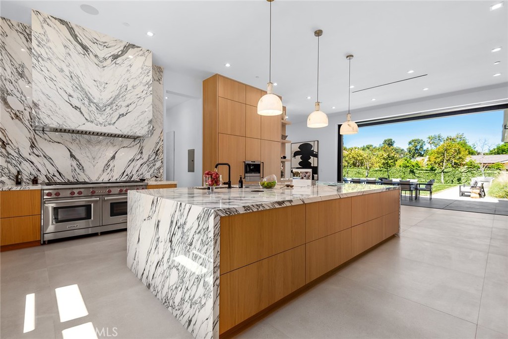 23650 Long Valley Road Hidden Hills, CA 91302 - Photo 13 of 57 a large kitchen with stainless steel appliances kitchen island granite countertop a stove a sink and a microwave
