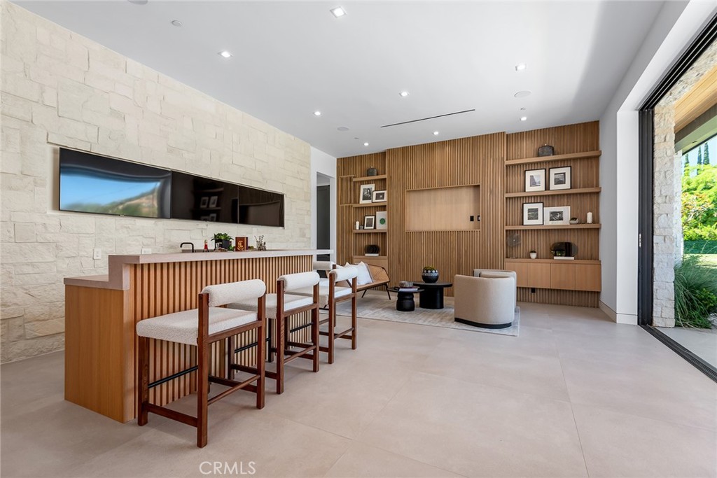 23650 Long Valley Road Hidden Hills, CA 91302 - Photo 18 of 57 a living room with furniture a flat screen tv and a floor to ceiling window