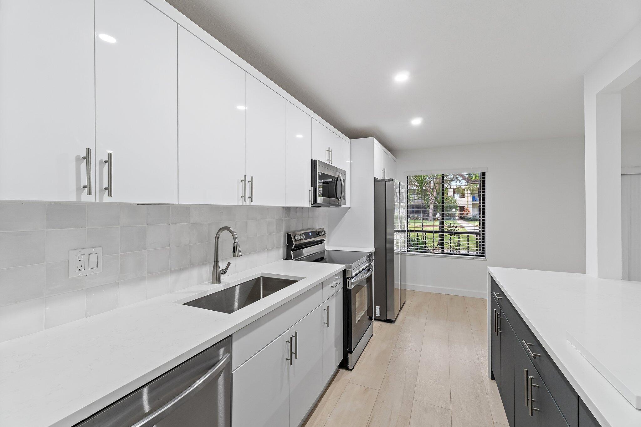 150 Pineview Road, Unit I4 Jupiter, FL 33469 - Photo 3 of 13 a kitchen that has a sink and a stove