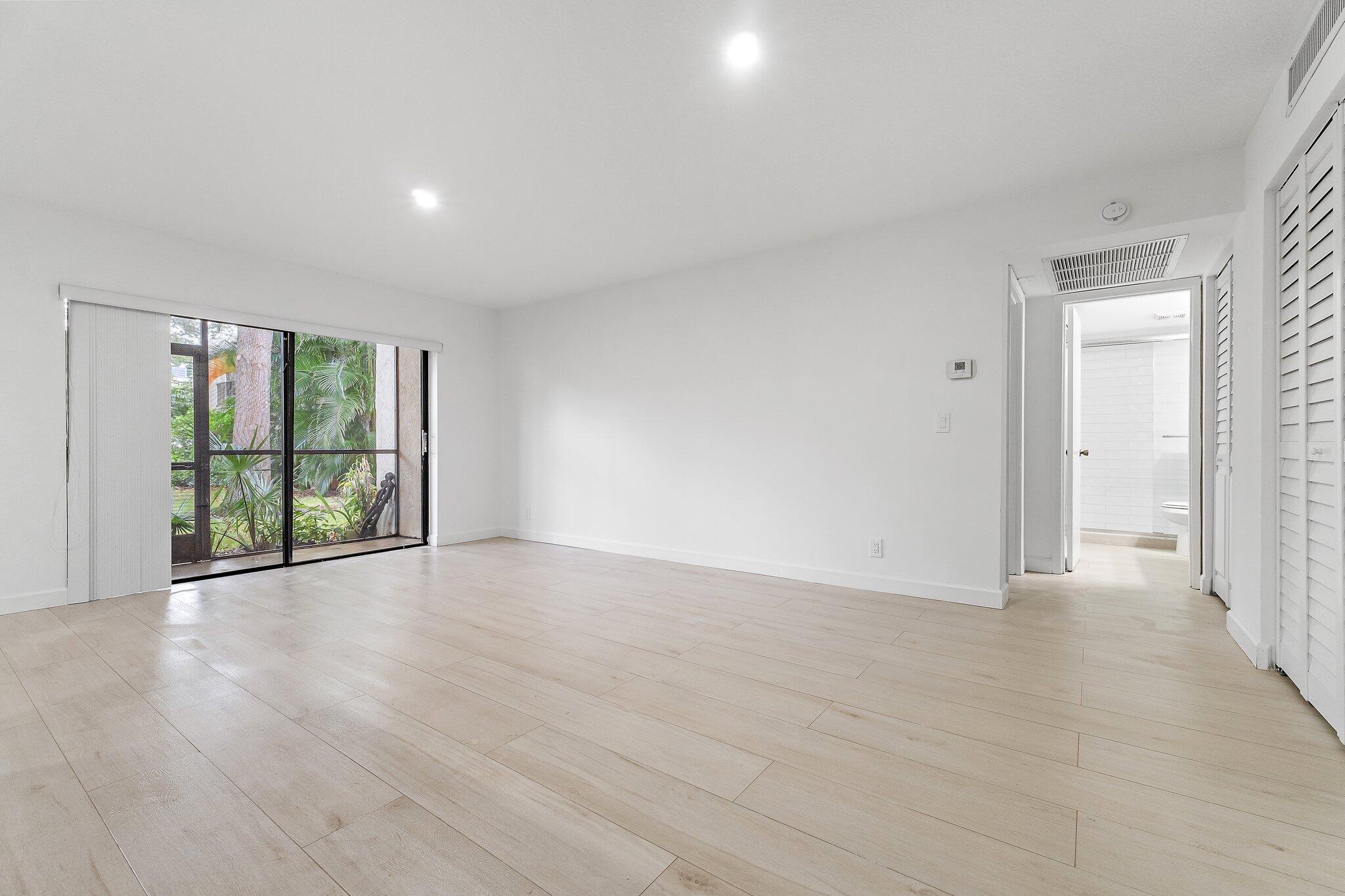 150 Pineview Road, Unit I4 Jupiter, FL 33469 - Photo 7 of 13 a view of an empty room with wooden floor and a window