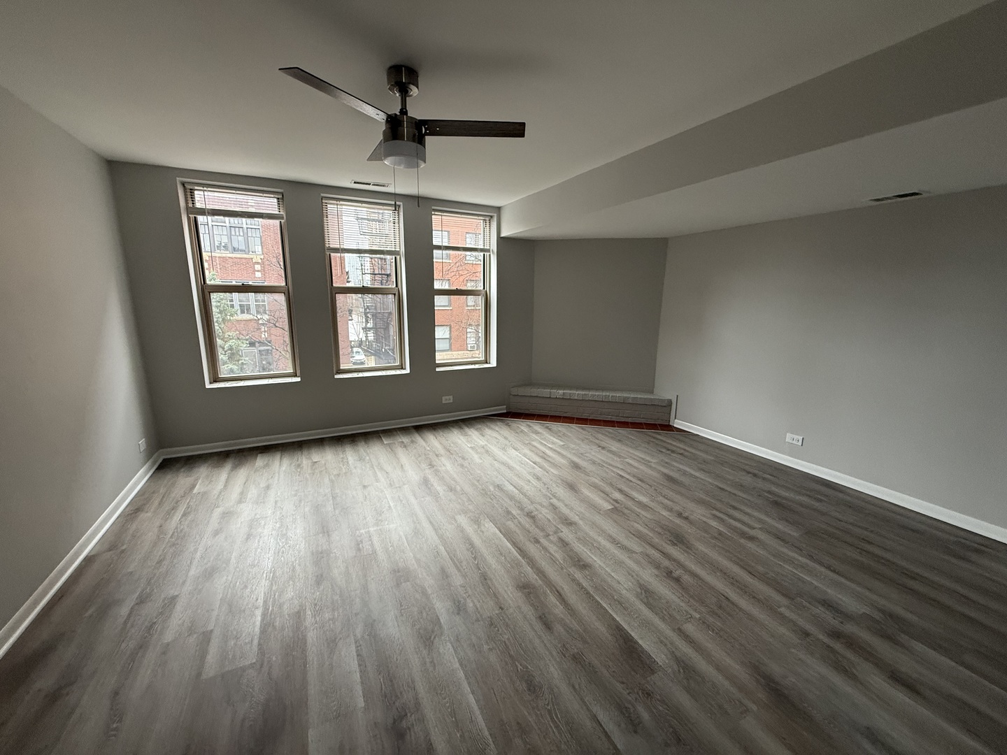 744 West Gordon Terrace, Unit 301 Chicago, IL 60613 - Photo 3 of 13 an empty room with wooden floor and windows
