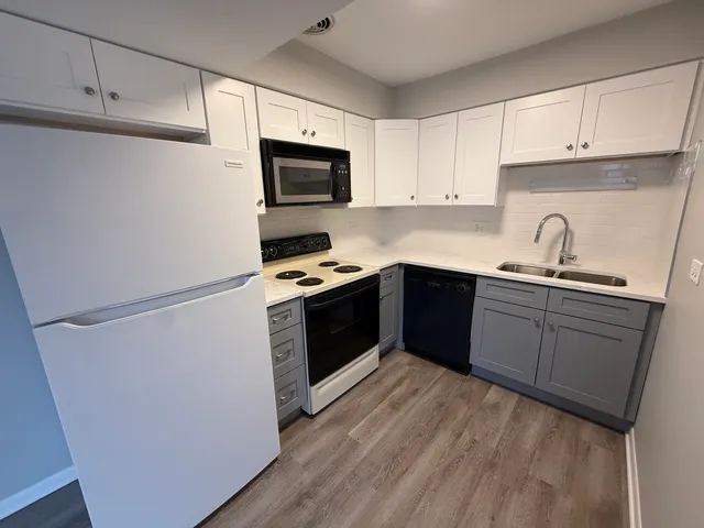 a kitchen with sink a microwave and cabinets