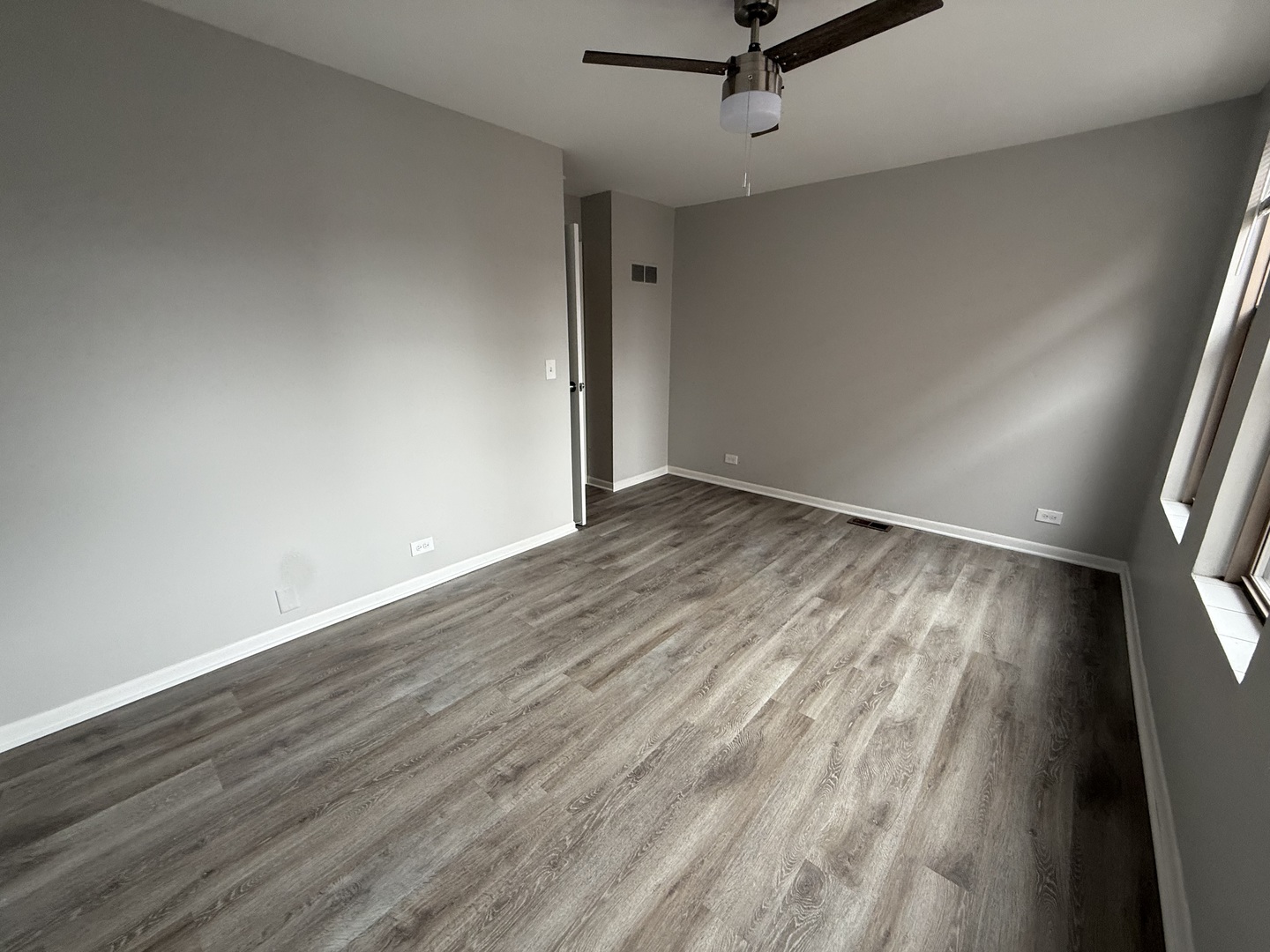 744 West Gordon Terrace, Unit 301 Chicago, IL 60613 - Photo 10 of 13 an empty room with wooden floor a ceiling fan and windows