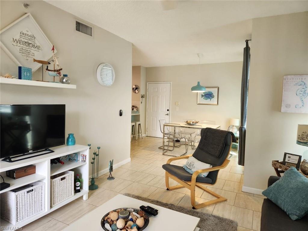 1200 Reserve Way, Unit 201 Naples, FL 34105 - Photo 2 of 20 a living room with furniture and a flat screen tv