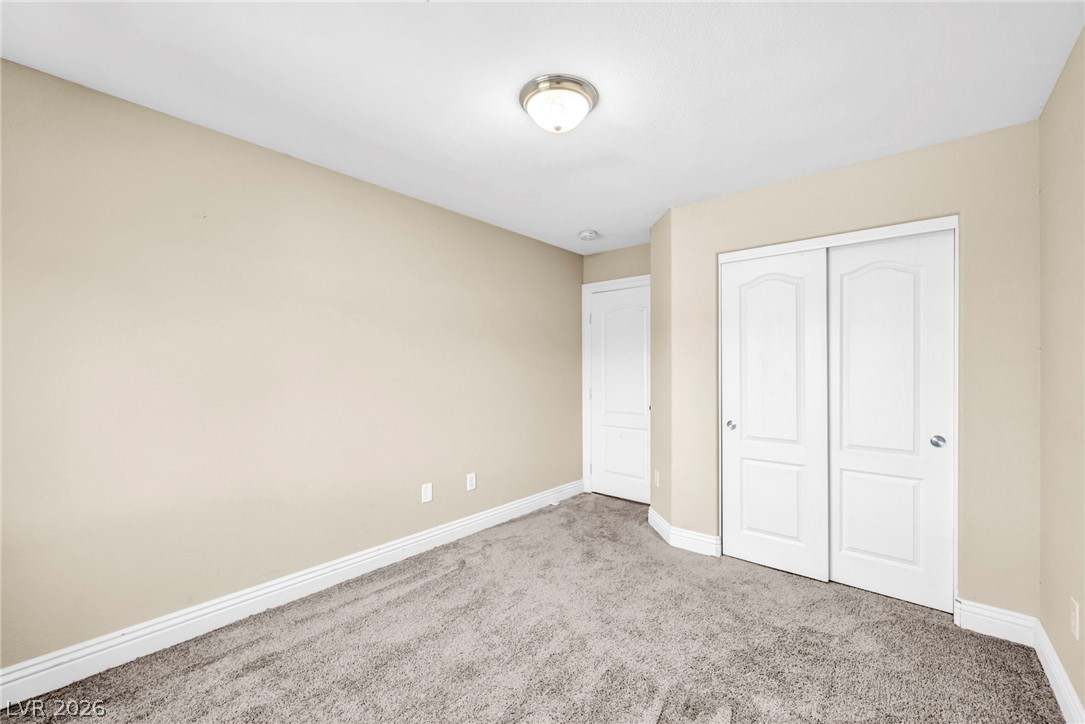 6405 North Raptor Court North Las Vegas, NV 89084 - Photo 31 of 66 A well-lit bedroom features plush carpeting and convenient sliding closet doors.
