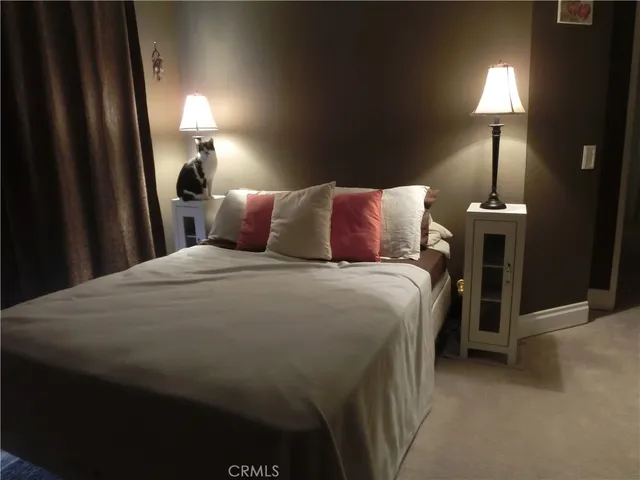 a bed sitting in a bedroom next to a lamp