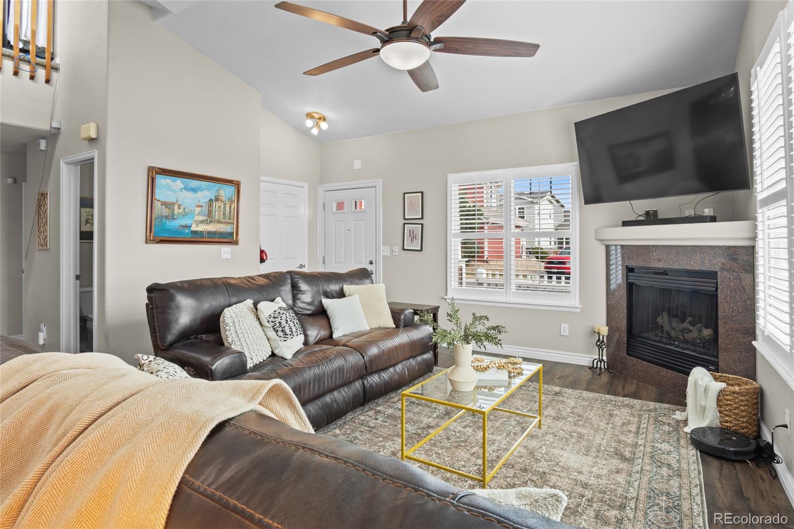 10550 Paris Street, Unit 705 Henderson, CO 80640 - Photo 4 of 30 a living room with furniture a fireplace and a flat screen tv