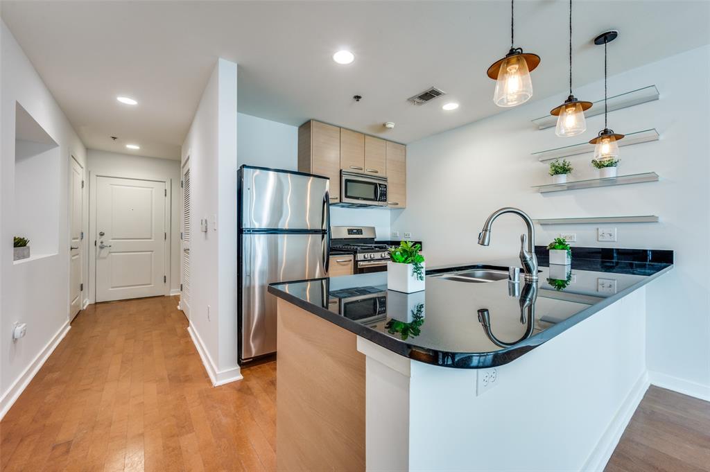 1200 Main Street, Unit 1908 Dallas, TX 75202 - Photo 5 of 27 a kitchen with stainless steel appliances granite countertop a sink and a refrigerator