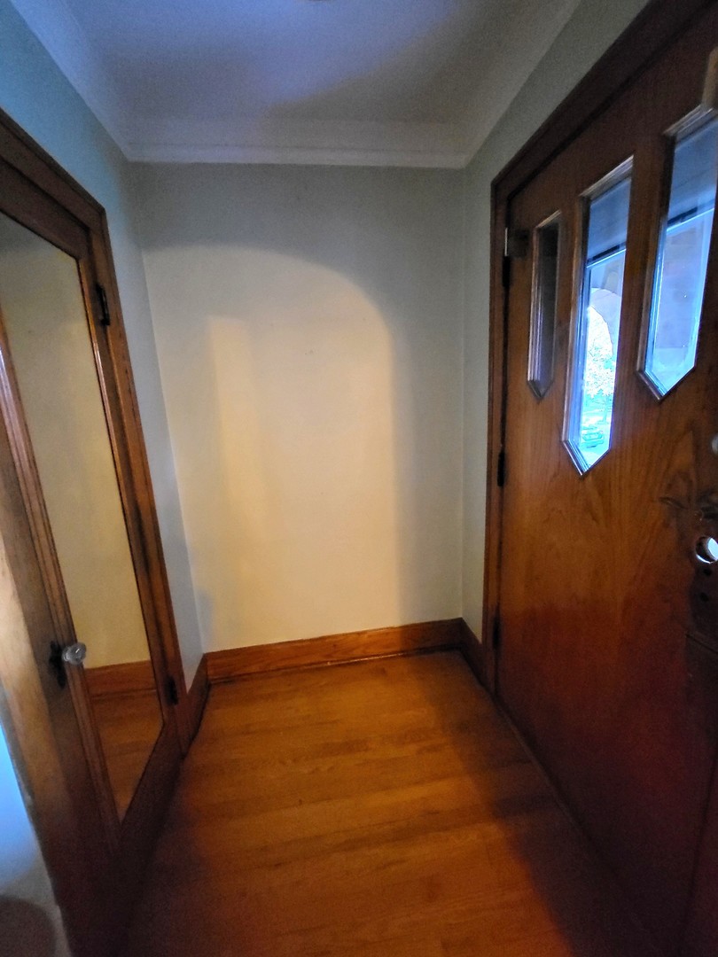 2939 North Lotus Avenue Chicago, IL 60641 - Photo 3 of 33 a view of an empty room with wooden floor and door