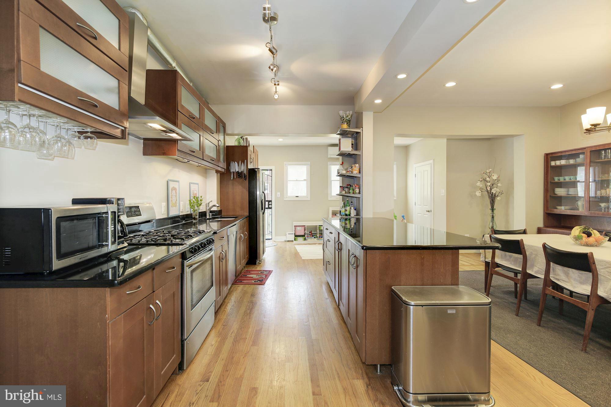 730 Rittenhouse Street Northwest Washington, DC 20011 - Photo 12 of 30 a kitchen with stainless steel appliances granite countertop a stove top oven a sink dishwasher a dining table and chairs with wooden floor