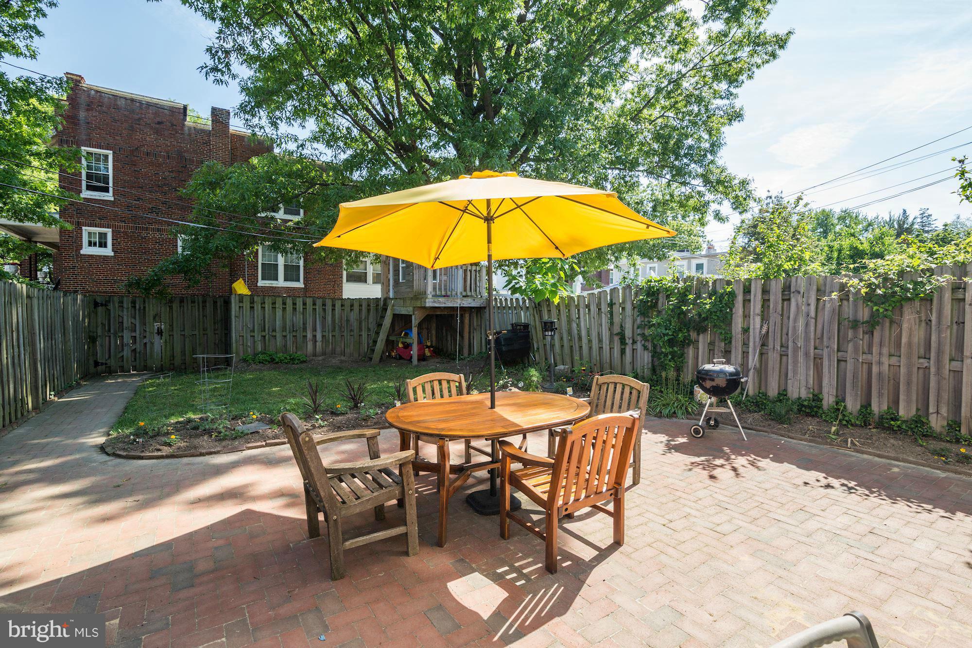 730 Rittenhouse Street Northwest Washington, DC 20011 - Photo 27 of 30 a view of a backyard with a table and chairs under an umbrella