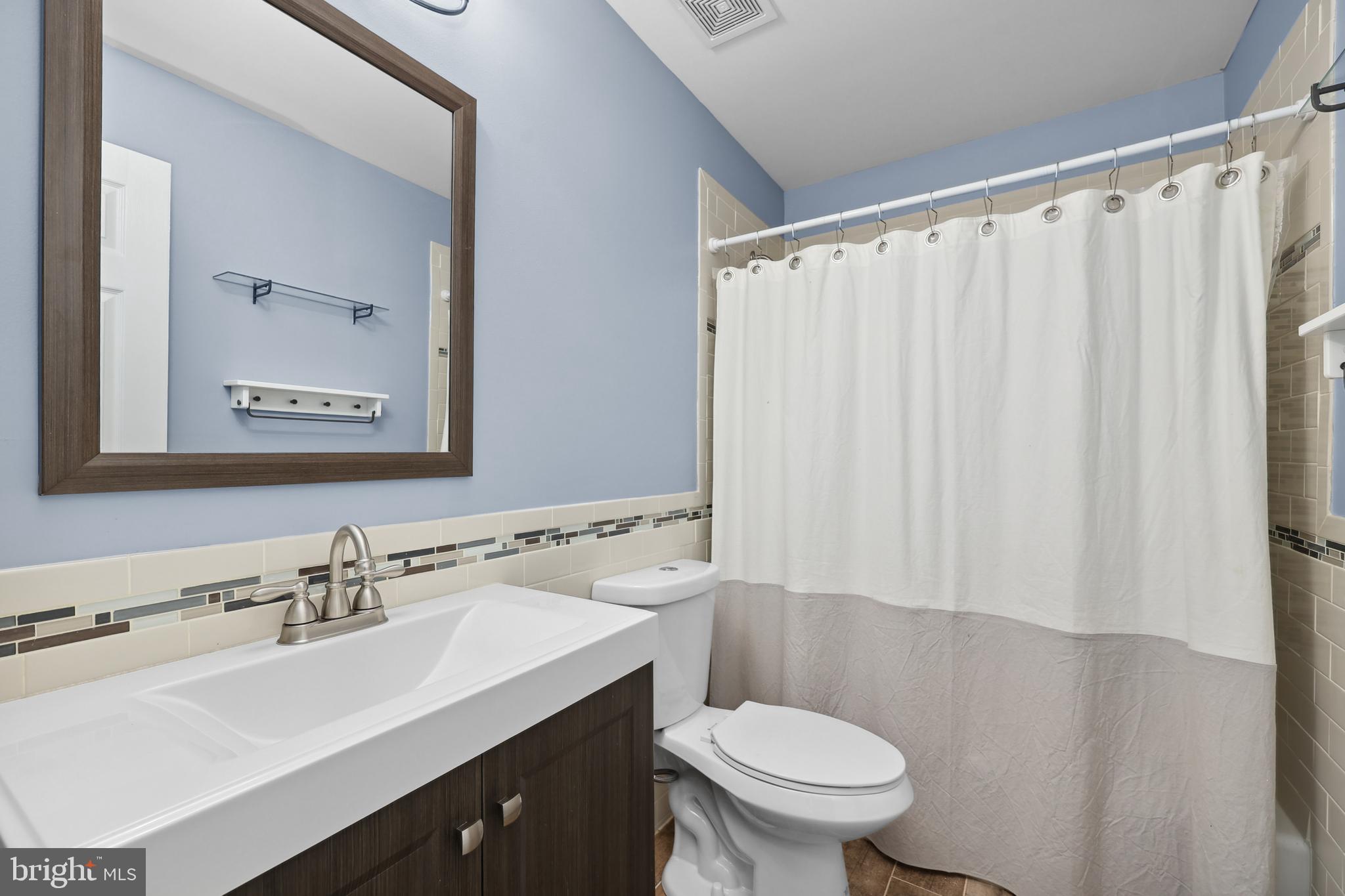 7103 Catlett Road Bealeton, VA 22712 - Photo 37 of 42 a bathroom with a sink a toilet a mirror and shower curtain