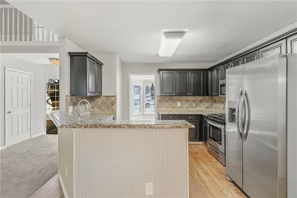 a kitchen with granite countertop a refrigerator and a sink
